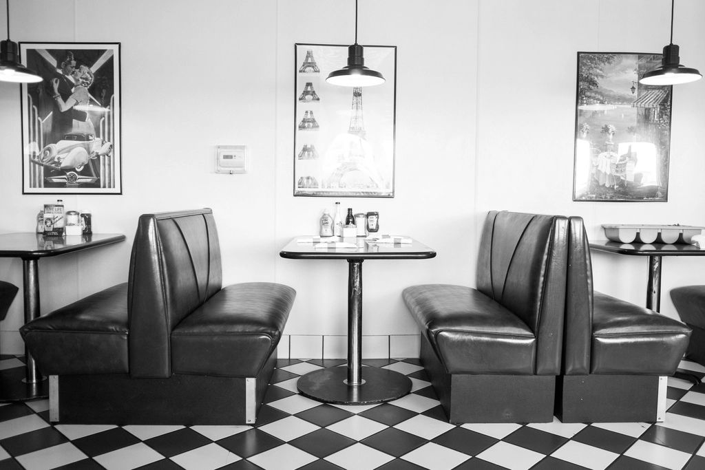 Black-and-white photo of old diner booths and a checkered floor