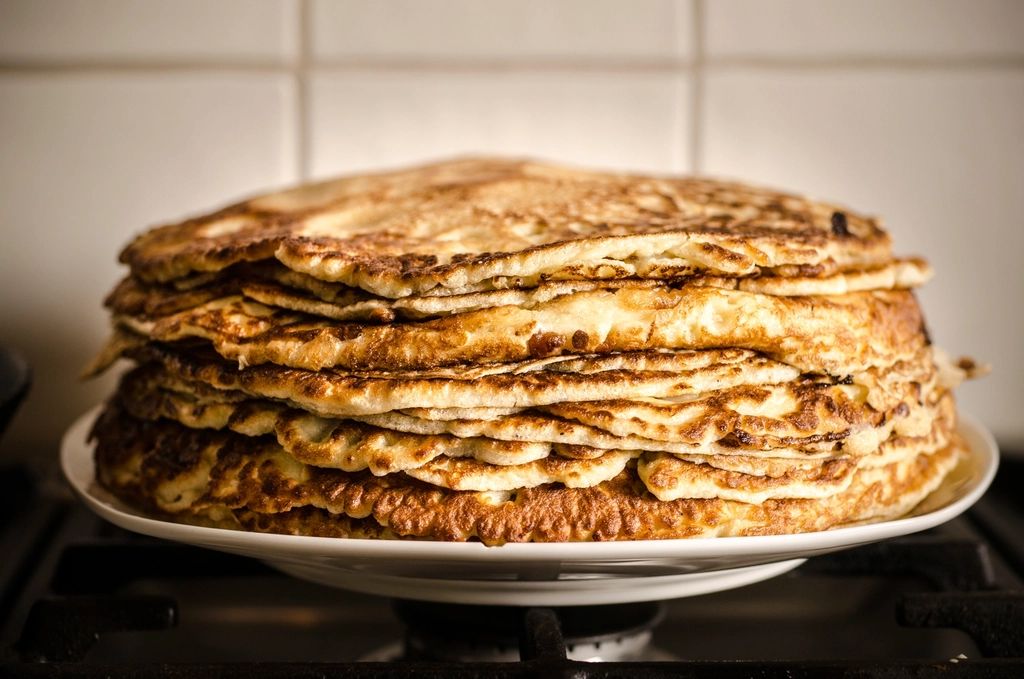 A tall stack of golden pancakes