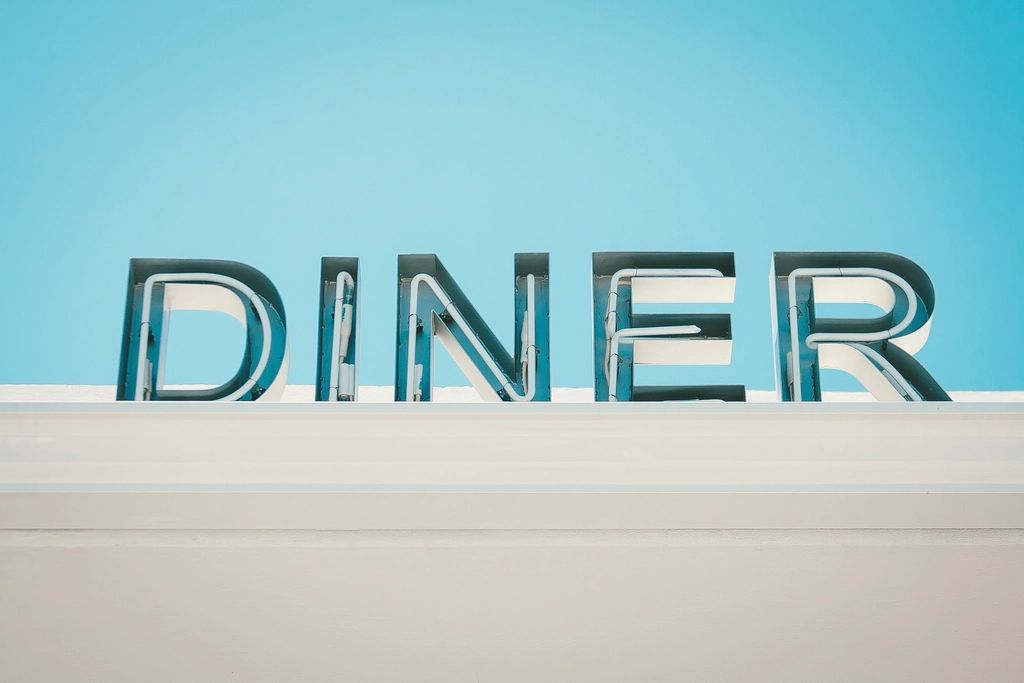 Big metal letters spelling DINER against a blue sky